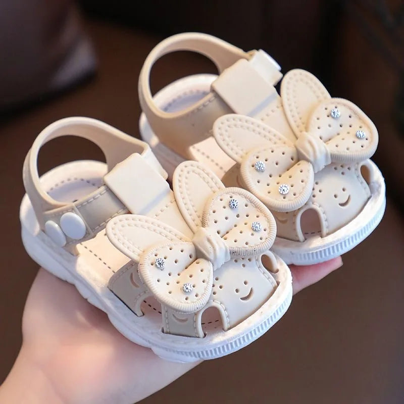 Nuevos zapatos de bebé de 0 a 3 años con bonito lazo y diamantes de imitación para niñas, sandalias antideslizantes de suela blanda para niños pequeños con dedos cubiertos